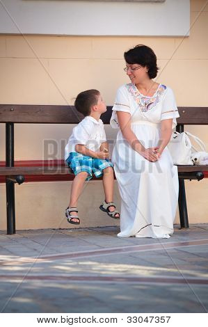 glÃ¼ckliche Mutter und Sohn sitzen auf Bank