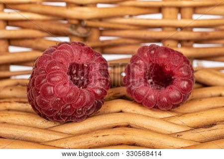 Group Of Two Whole Fresh Crimson Raspberry With Braided Rattan Behind