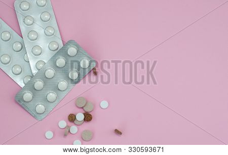 Assorted Pharmaceutical Medicine Pills, Tablets And Capsules On Pink Background. Top View. Flat Lay.