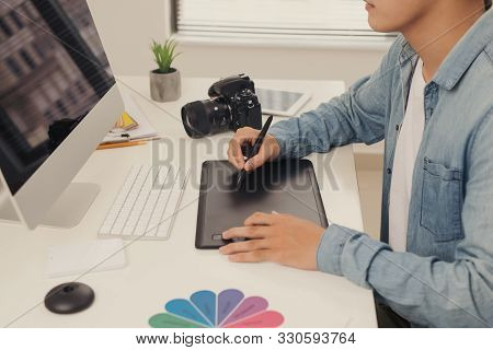 Photographer Drawing And Retouching Image On Laptop Computer, Using A Digital Tablet And Stylus Pen.