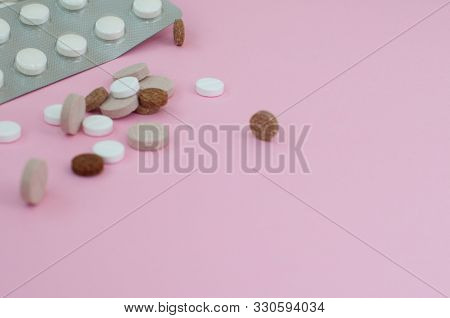 Assorted Pharmaceutical Medicine Pills, Tablets And Capsules On Pink Background. Top View. Flat Lay.
