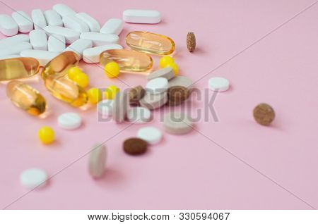 Assorted Pharmaceutical Medicine Pills, Tablets And Capsules On Pink Background. Top View. Flat Lay.