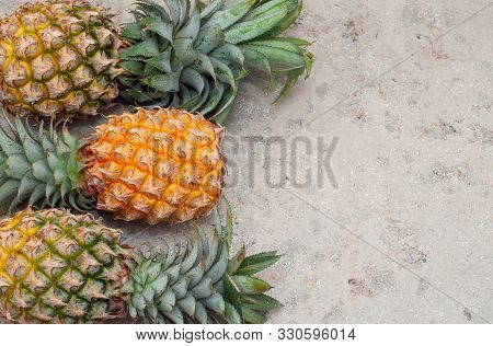 Yellow Mini Pineapple On A Gray Background. Pineapple From Thailand. Flat Lay. Copy Space.