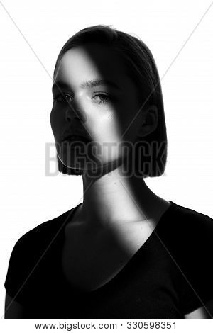Fashionable Beauty Portrait. Black Silhouette On White Background. Girl With A Spot Of Light On Her 