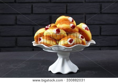 Berliner Pfannkuchen, German Donuts With Raspberry Jam And Cream Fillings On A Cake Stand On A Concr