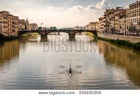 Florence / Italy - May 26 2018: A Rowing Boat In River Arno, With Old Medieval Buildings In The Rive