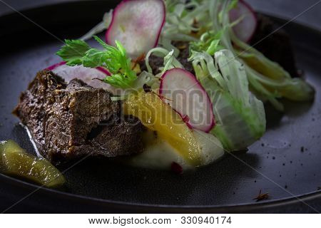 Close Up View On Glazed Beef Cheek With Celery Puree And Ginger Pear On Gray Background In Restauran