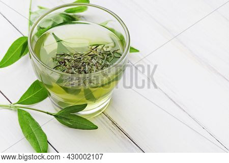 healthy green tea cup with tea leaves. healthy herbal tea, home remedy. beverage for cold flu treament, alternative medicine. natural immunity booster. Beverage for raising immunity concept