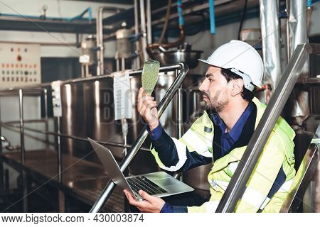 Cacusian Engineer Man Using Computer Notebook For Checking The Quality Of  Herbal Drinks, Which Cont