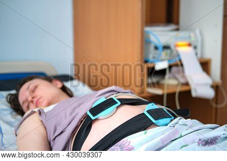 A Woman On A Clinic Bed During Labor Pains. A Pregnant Woman Gives Birth In A Hospital With A Drip A