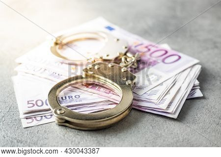 Euro banknotes and a handcuffs.