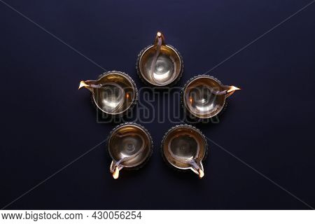 Lit Diyas On Dark Background, Flat Lay. Diwali Lamps