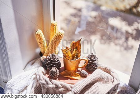 Corns, Autumn Leaves, Pine Cones And Coffee Cup On Windowsill. Creative Autumnal Background Near The