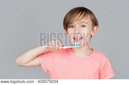 Joyful Child Shows Toothbrushes. Little Boy Cleaning Teeth. Dental Hygiene. Happy Little Kid Brushin
