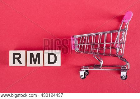 The Word Rmd - Required Minimum Distribution, On Wooden Cubes, On A Pink Background With A Shopping 