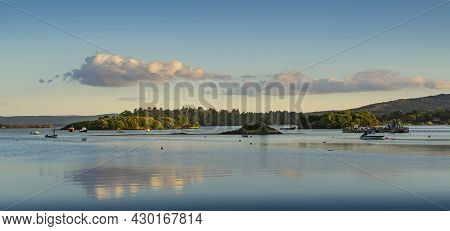 Panoramic Landscape Of A Sunset On A Lake In Ireland With Clouds Reflected In The Water.