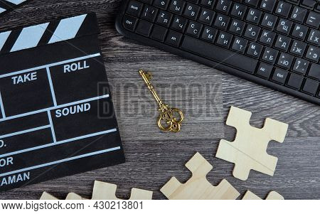 Cinematic  Clapper, Pc Keyboard, Golden Key And Puzzle Pieces On A Table Top View