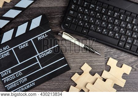 Cinematic  Clapper, Pc Keyboard, Pen And Puzzle Pieces On A Table Top View