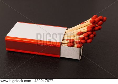 Matches In An Open Matchbox On A Black Background. A Blank, White Label On The Matchbox.