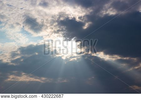 Holy Light Comes From Heaven. Sun Rays Pass Through Dark Cloudy Sky With Bright Pillars Of Light.