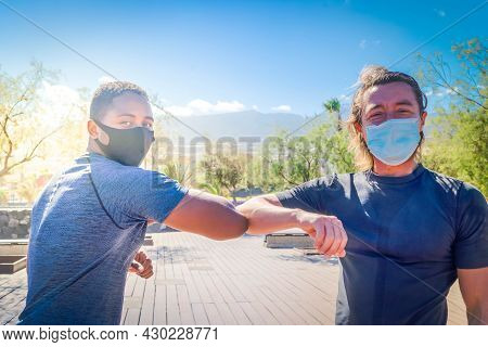 Covid-19 Pandemia Greeting With Elbows Bump Of Afro American Man And Caucsian Man