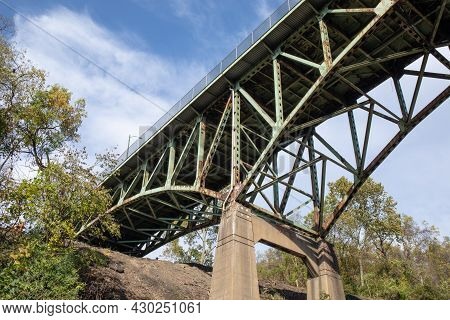 View Looking Up At An Old Bridge Showing Structural Deficiencies, Rusted Metal And Crumbling Concret