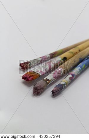 Dirty Art Paint Brusches Of Different Sizes And Colors On White Background, Copy Space