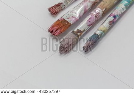 Dirty Art Paint Brusches Of Different Sizes And Colors On White Background, Copy Space