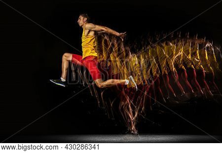 Portrait Of Young Man, Professional Male Athlete, Runner In Motion And Action Isolated On Dark Backg