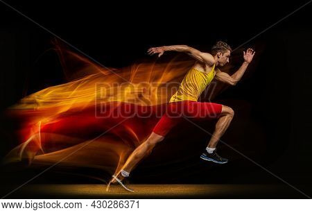 Portrait Of Young Man, Professional Male Athlete, Runner In Motion And Action Isolated On Dark Backg