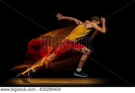 Portrait Of Young Man, Professional Male Athlete, Runner In Motion And Action Isolated On Dark Backg