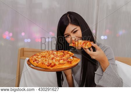 Beautiful Asian Girl Eats Pizza Gluttony Is Dinner, Eaten Before Bedtime, Eating In Bed In Her House