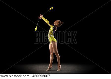 Portrait Of Little Girl, Rhythmic Gymnastics Artist In Bright Stage Costume Isolated On Dark Studio 