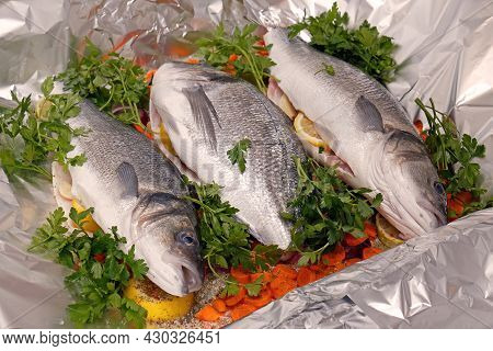 Fresh Raw Sea Bass And Sea Bream Ready For Baking With Carrots, Lemon, Red Onion, Garlic, Parsley An