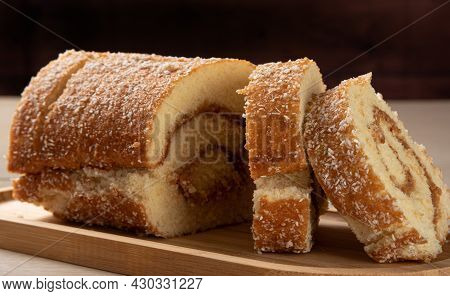 Rocambole, Sliced ​​rocambole Stuffed With Dulce De Leche On A Wooden Tray On A Table. Dark Backgrou