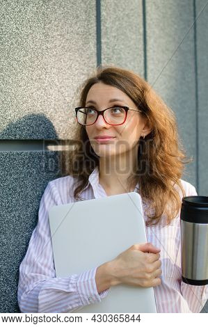 Female Portrait Of Young Woman With Silver Laptop And Cup Of Coffee Waiting For A Meeting Near Dark 
