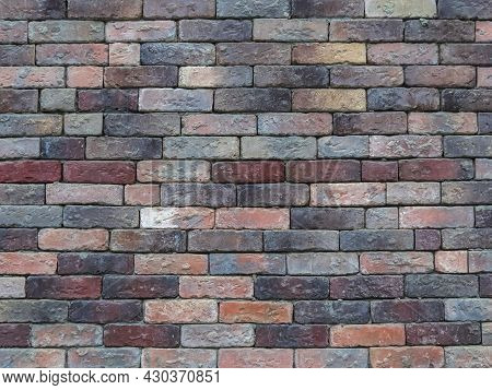 The Neutral Texture Of The Multicolored Brick Wall Of An Old Building. Dirty Colored Bricks Sloppily