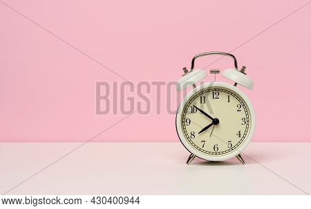 White Metal Alarm Clock On A White Table, Ten To Eight In The Morning, Copy Space