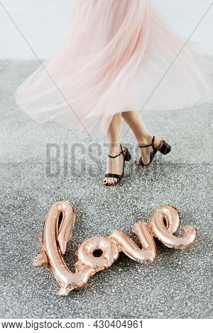 Woman dancing by the foil balloon on the ground