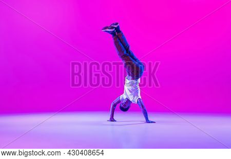 Young Stylish Man, Hip-hop Dancer Dancing Solo In Modern Clothes Isolated Over Bright Magenta Backgr
