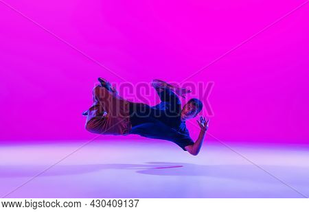 Young Stylish Man, Break Dancing Dancer Practicing Solo In Modern Clothes Isolated Over Bright Magen