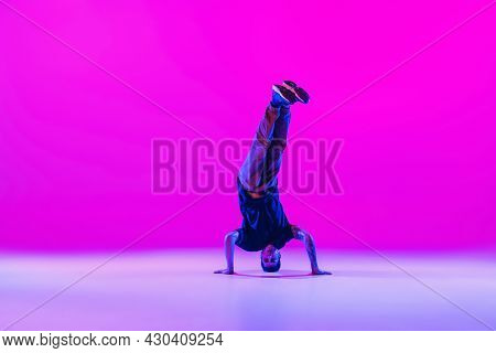 Portrait Of Dancing Man, Break Dancer In Action, Motion In Modern Clothes Isolated Over Bright Magen