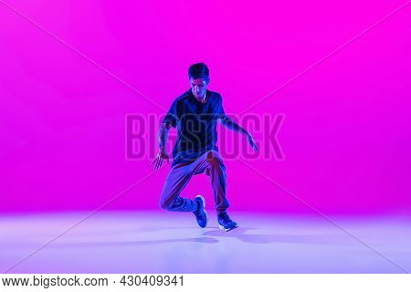 Young Stylish Man, Hip-hop Dancer Dancing Solo In Modern Clothes Isolated Over Bright Magenta Backgr
