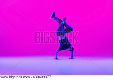 Portrait Of Dancing Man, Break Dancer In Action, Motion In Modern Clothes Isolated Over Bright Magen