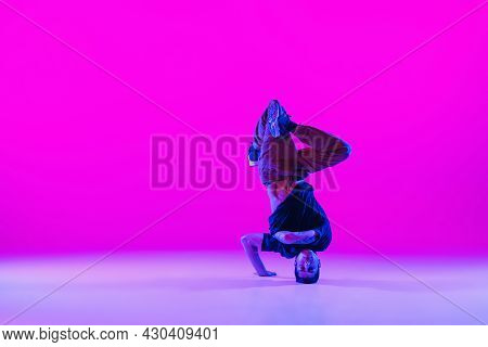 Portrait Of Young Man, Break-dance Dancer Dancing Solo In Modern Clothes Isolated Over Bright Magent