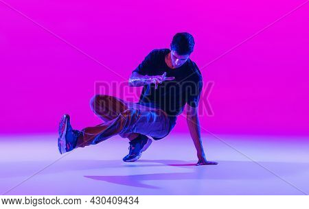 Portrait Of Dancing Man, Break Dancer In Action, Motion In Modern Clothes Isolated Over Bright Magen