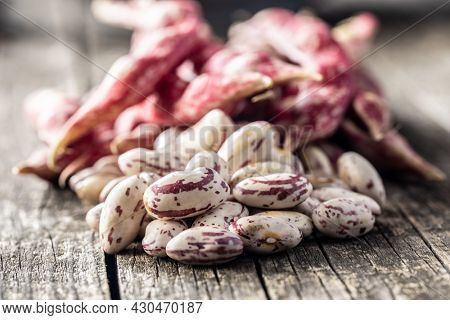 Cranberry beans. Borlotti beans. Beans pods on wooden table.