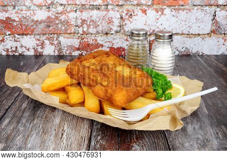 Battered Cod Fish And Chips Meal Wrapped In Brown Paper