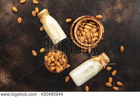 Plant Based Almod Milk In Bottles On Brown Background. Copy Space. Top View
