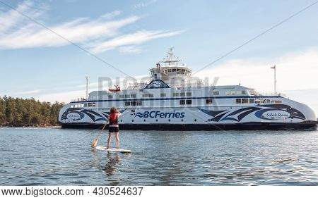 Victoria, Vancouver Island, British Columbia, Canada - August 15, 2021: Adventurous Woman Paddle Boa